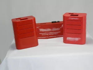 Two red plastic blocks on a white surface with a white background